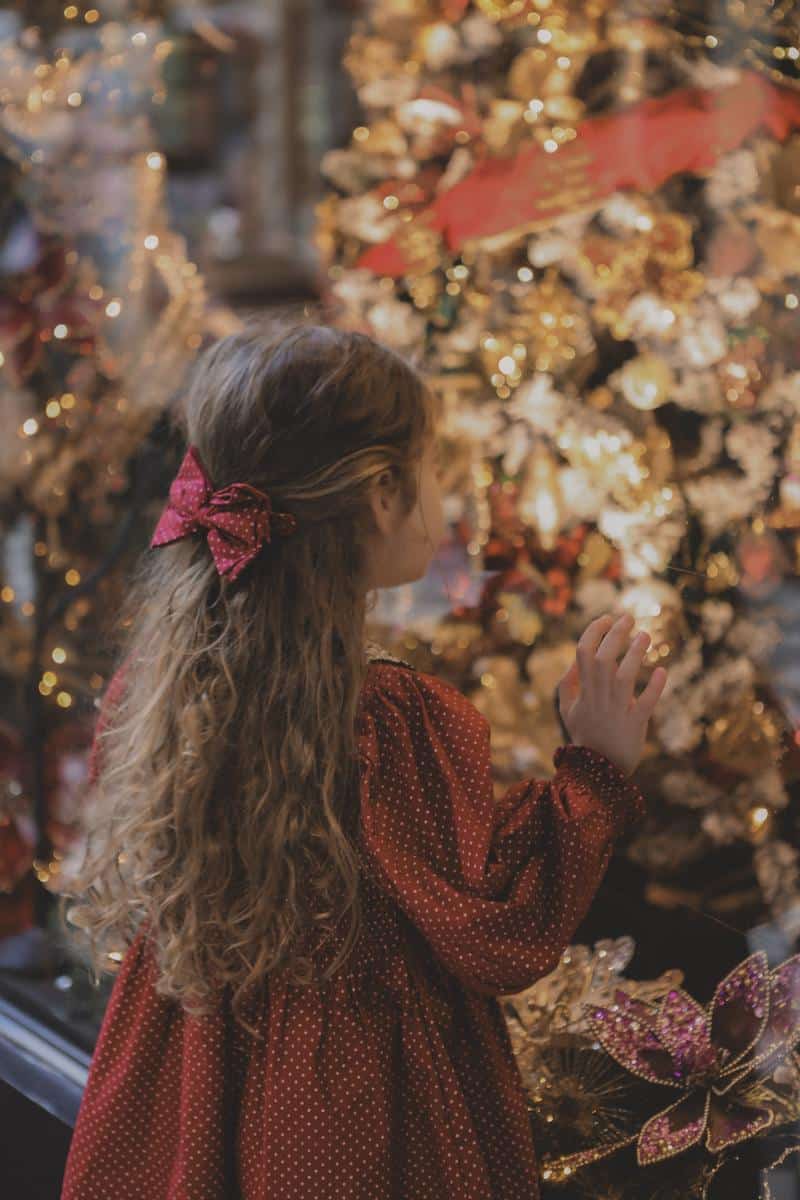 Little girl at christmas looking through the parisian toy store