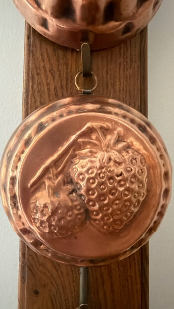 Vintage Copper Fruit Moulds on Wooden Wall Rack