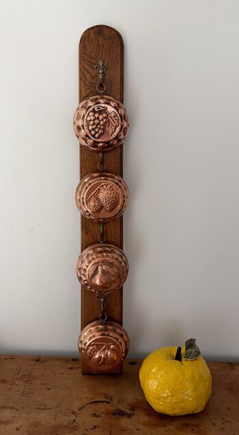 Vintage Copper Fruit Moulds on Wooden Wall Rack